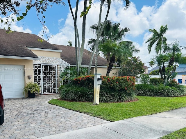 13205 SW 119th St, Miami, FL 33186 - view of side of property with stucco siding, an attached garage, roof with shingles, and decorative driveway