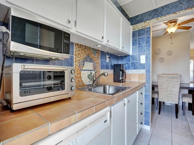 16901 NE 13th Ave Unit 110, Miami, FL 33162 - kitchen with tile counters, white cabinetry, decorative backsplash, and ceiling fan