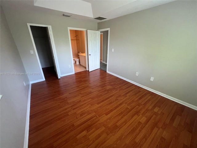 2620 SE 14th Ave Unit 304, Homestead, FL 33035 - unfurnished bedroom featuring a spacious closet, dark wood finished floors, a closet, and ensuite bathroom
