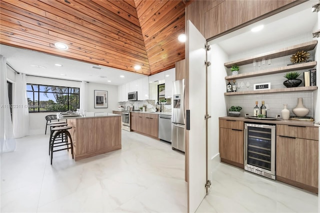 2019 NW 108th Ln, Coral Springs, FL 33071 - kitchen featuring wine cooler, modern cabinets, stainless steel appliances, a kitchen breakfast bar, and tasteful backsplash
