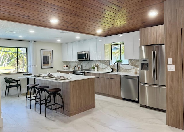 2019 NW 108th Ln, Coral Springs, FL 33071 - kitchen featuring stainless steel appliances, modern cabinets, wood ceiling, a kitchen bar, and plenty of natural light