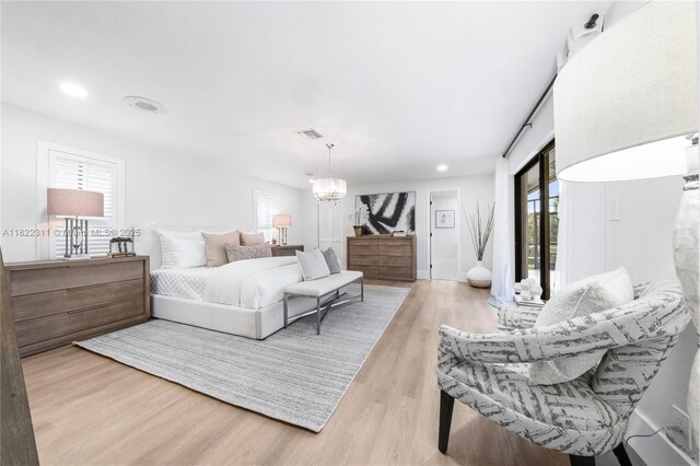 2019 NW 108th Ln, Coral Springs, FL 33071 - bedroom with multiple windows, a chandelier, and wood finished floors