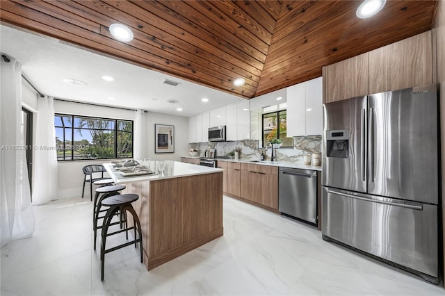 2019 NW 108th Ln, Coral Springs, FL 33071 - kitchen featuring stainless steel appliances, modern cabinets, a kitchen island, light countertops, and white cabinetry