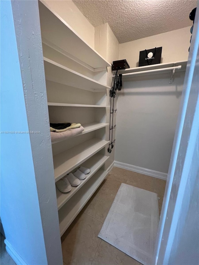 9273 Collins Ave Unit 706, Surfside, FL 33154 - walk in closet with tile patterned floors