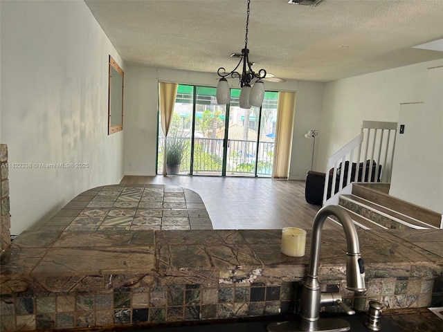 12666 NW 14th Pl Unit 12666, Sunrise, FL 33323 - living room with a textured ceiling, a chandelier, wood finished floors, and stairs
