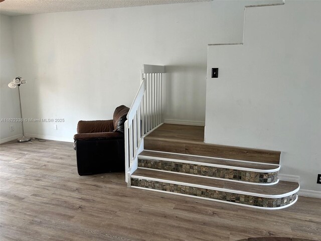 12666 NW 14th Pl Unit 12666, Sunrise, FL 33323 - stairway featuring wood finished floors and a textured ceiling