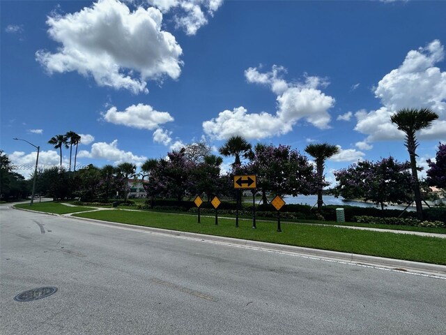 12666 NW 14th Pl Unit 12666, Sunrise, FL 33323 - view of asphalt street with traffic signs, curbs, street lights, and sidewalks