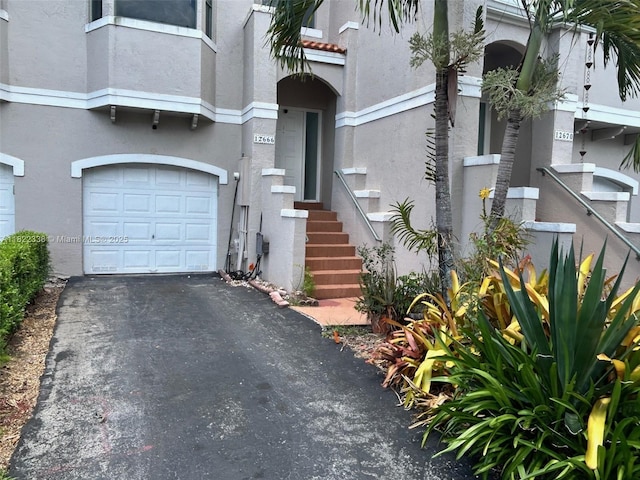 12666 NW 14th Pl Unit 12666, Sunrise, FL 33323 - property entrance featuring an attached garage, stucco siding, and driveway