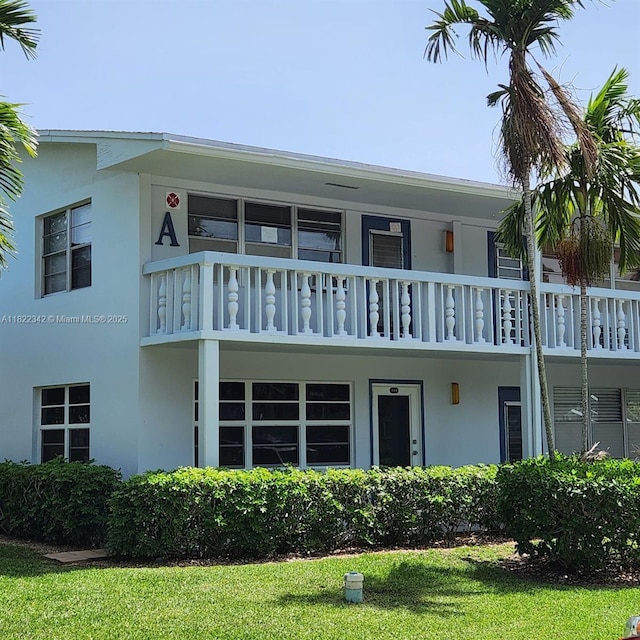 20 Prescott A 20, Deerfield Beach, FL 33442 - rear view of property featuring stucco siding, a balcony, and a lawn