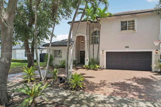 8981 NW 166th Ter, Miami Lakes, FL 33018 - mediterranean / spanish-style home with stucco siding, an attached garage, decorative driveway, and a tile roof