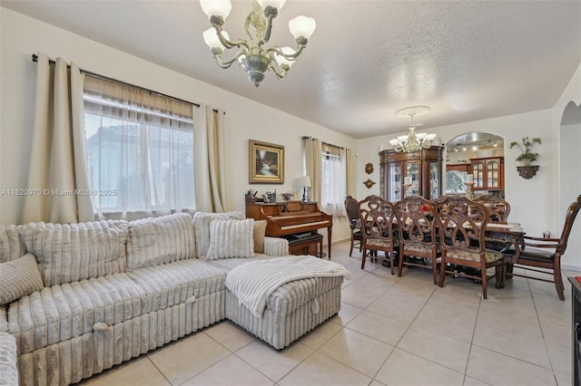 8981 NW 166th Ter, Miami Lakes, FL 33018 - living room with a chandelier, light tile patterned flooring, a textured ceiling, and arched walkways