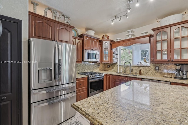 8981 NW 166th Ter, Miami Lakes, FL 33018 - kitchen with stainless steel appliances, tasteful backsplash, glass insert cabinets, and light stone countertops