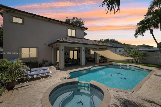 8981 NW 166th Ter, Miami Lakes, FL 33018 - pool at dusk featuring a patio area and a pool with connected hot tub