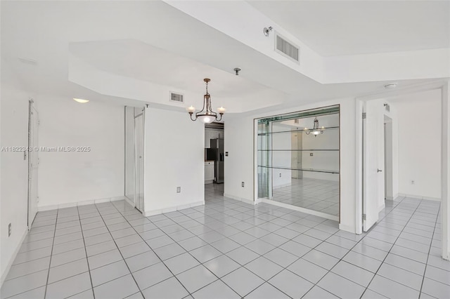 9341 Collins Ave Unit 705, Surfside, FL 33154 - spare room featuring a chandelier, light tile patterned flooring, and a tray ceiling