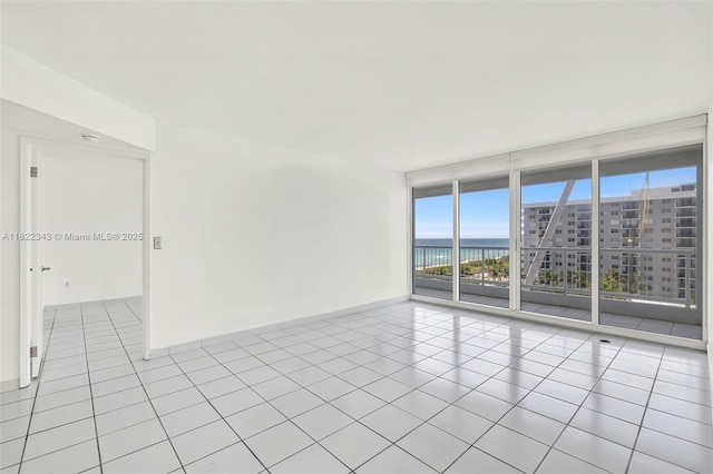 9341 Collins Ave Unit 705, Surfside, FL 33154 - unfurnished room with expansive windows, plenty of natural light, tile patterned floors, and a water view