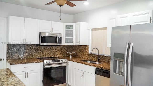 7795 Granada Blvd, Miramar, FL 33023 - kitchen featuring stainless steel appliances, dark stone counters, white cabinetry, glass insert cabinets, and tasteful backsplash
