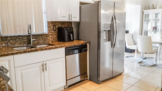7795 Granada Blvd, Miramar, FL 33023 - kitchen with appliances with stainless steel finishes, white cabinets, backsplash, dark stone countertops, and light tile patterned floors