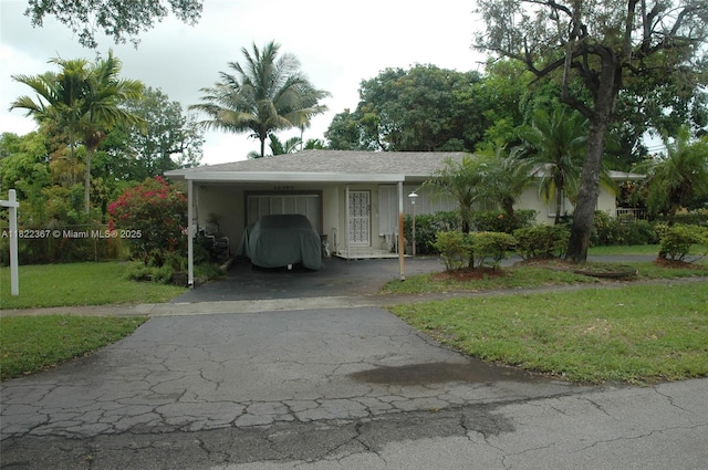 12385 NW 4th Ave, North Miami, FL 33168 - view of front of home with asphalt driveway, a front lawn, a carport, and stucco siding