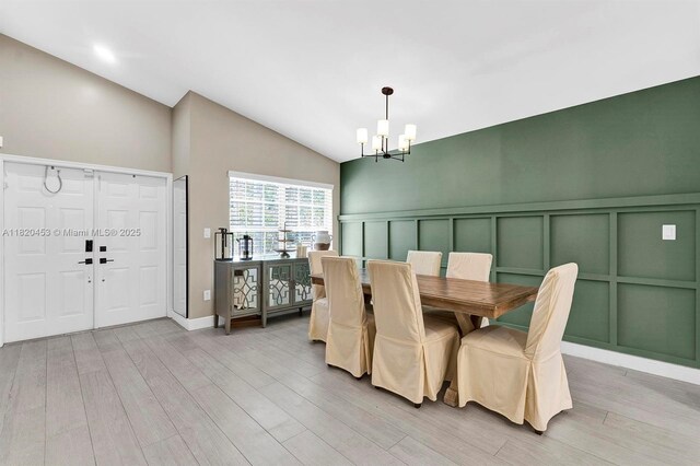 142 SW 204th Ave, Pembroke Pines, FL 33029 - dining space with a chandelier, a decorative wall, vaulted ceiling, light wood-style flooring, and wainscoting