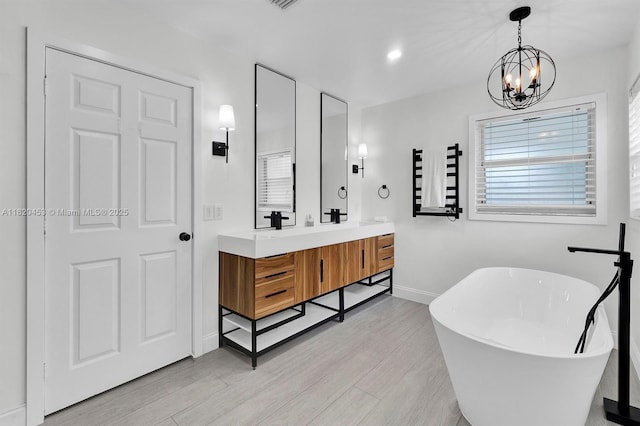 142 SW 204th Ave, Pembroke Pines, FL 33029 - full bath featuring a freestanding bath, double vanity, a chandelier, and wood finished floors