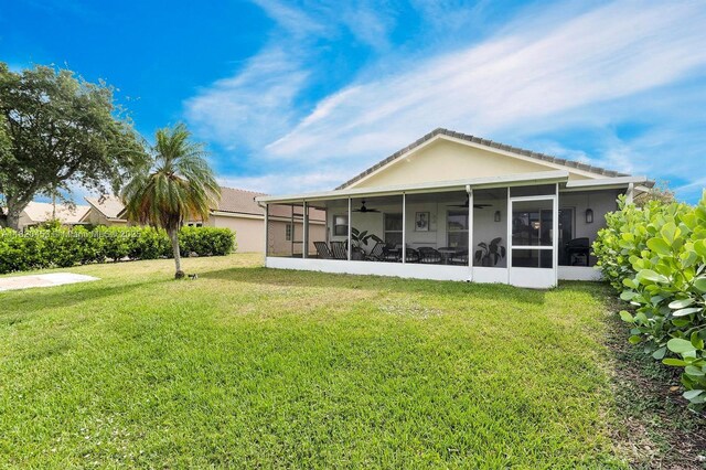 142 SW 204th Ave, Pembroke Pines, FL 33029 - rear view of house with a sunroom, ceiling fan, a yard, and stucco siding