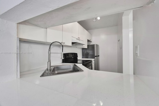 7403 SW 82nd St Unit 207N, Miami, FL 33143 - kitchen featuring electric range, under cabinet range hood, white cabinetry, freestanding refrigerator, and light countertops