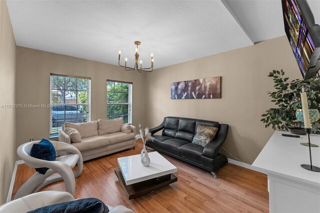 16101 SW 104th Ter, Miami, FL 33196 - living room with a chandelier, light wood-type flooring, and a textured ceiling