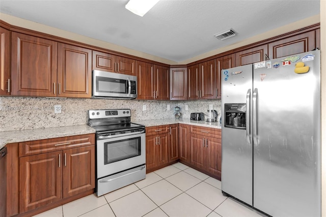 16101 SW 104th Ter, Miami, FL 33196 - kitchen featuring stainless steel appliances, light tile patterned flooring, tasteful backsplash, light stone countertops, and brown cabinetry