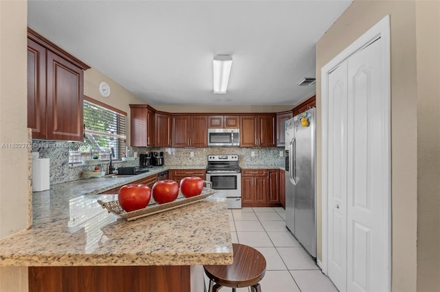 16101 SW 104th Ter, Miami, FL 33196 - kitchen featuring stainless steel appliances, backsplash, light tile patterned flooring, a peninsula, and a breakfast bar area
