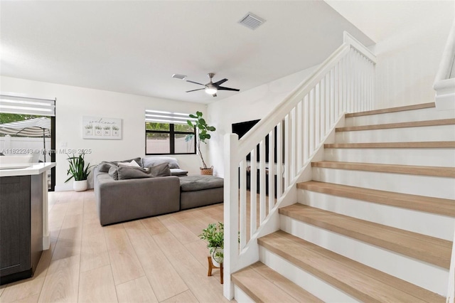 10129 W 32nd Ln, Hialeah, FL 33018 - living room featuring stairs, light wood-style flooring, and a ceiling fan