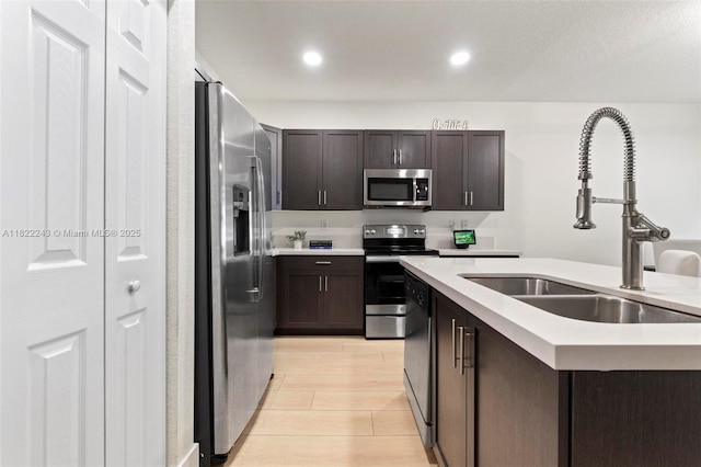 10129 W 32nd Ln, Hialeah, FL 33018 - kitchen featuring appliances with stainless steel finishes, light countertops, dark brown cabinets, light wood finished floors, and recessed lighting