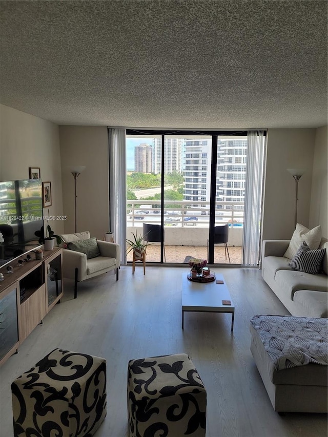 3300 NE 192nd St Unit 1008, Aventura, FL 33180 - living area featuring expansive windows, wood finished floors, and a textured ceiling