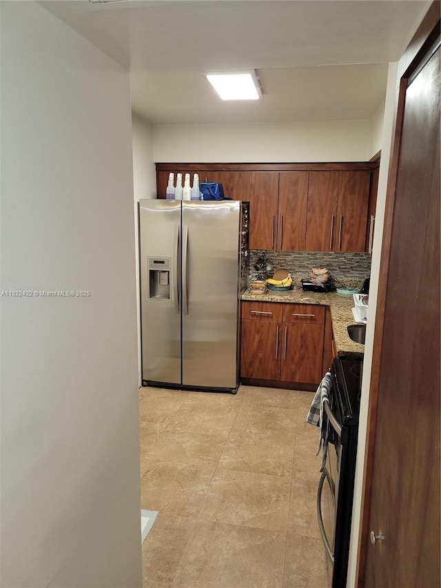 3300 NE 192nd St Unit 1008, Aventura, FL 33180 - kitchen featuring stainless steel fridge with ice dispenser, black range, light stone countertops, decorative backsplash, and brown cabinetry