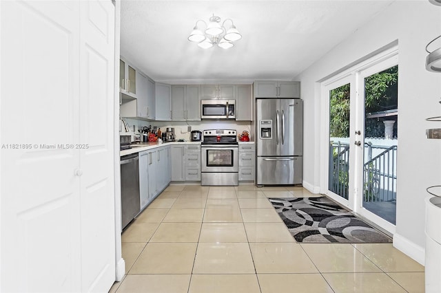 3430 NW 16th St, Miami, FL 33125 - kitchen featuring appliances with stainless steel finishes, gray cabinetry, light countertops, light tile patterned floors, and french doors