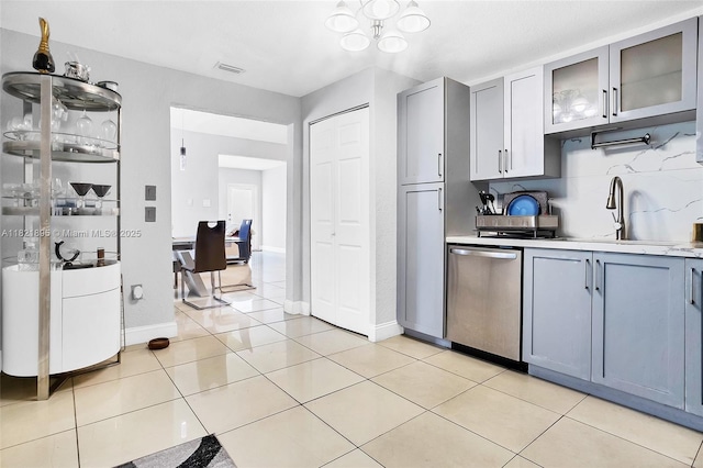 3430 NW 16th St, Miami, FL 33125 - kitchen featuring stainless steel dishwasher, gray cabinets, light countertops, and glass insert cabinets