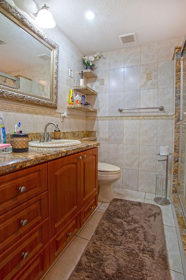 3430 NW 16th St, Miami, FL 33125 - bathroom featuring tile walls, a textured ceiling, tile patterned flooring, vanity, and a shower stall