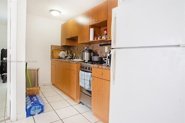3430 NW 16th St, Miami, FL 33125 - kitchen featuring freestanding refrigerator, gas range, decorative backsplash, open shelves, and light tile patterned flooring