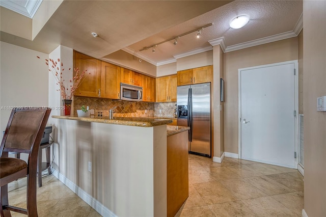 1755 E Hallandale Beach Blvd Unit 608E, Hallandale Beach, FL 33009 - kitchen with appliances with stainless steel finishes, crown molding, rail lighting, stone countertops, and a peninsula