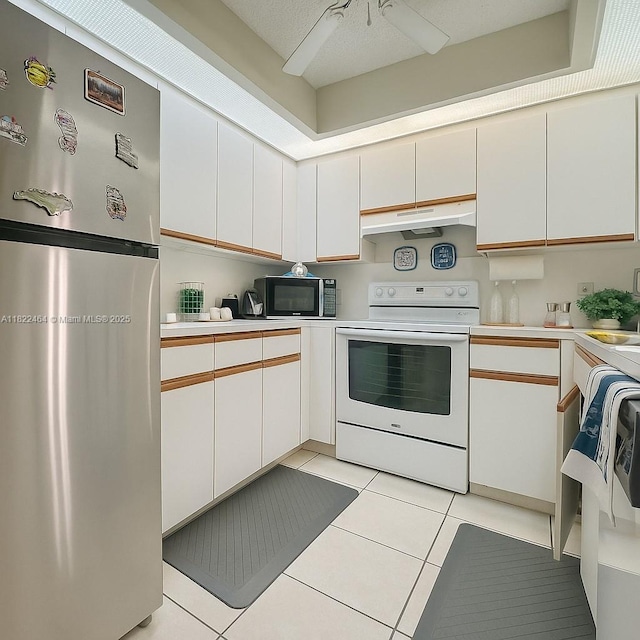 12500 SW 5th Ct Unit 112M, Pembroke Pines, FL 33027 - kitchen featuring freestanding refrigerator, white range with electric cooktop, black microwave, under cabinet range hood, and light tile patterned floors