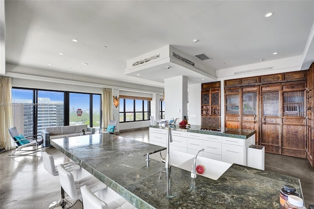 780 NE 69th St Unit T-1A, Miami, FL 33138 - kitchen featuring open floor plan, finished concrete flooring, white cabinets, stovetop, and recessed lighting