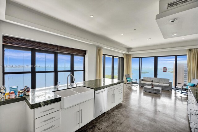 780 NE 69th St Unit T-1A, Miami, FL 33138 - kitchen featuring stainless steel dishwasher, concrete floors, white cabinets, open floor plan, and a water view