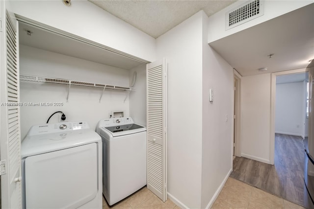 2711 Ocean Club Blvd Unit 207, Hollywood, FL 33019 - washroom with washer and dryer, light tile patterned floors, and a textured ceiling