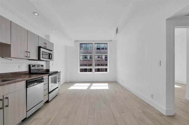 111 E Flagler St Unit 902, Miami, FL 33131 - kitchen featuring appliances with stainless steel finishes, light wood-style flooring, dark countertops, recessed lighting, and modern cabinets