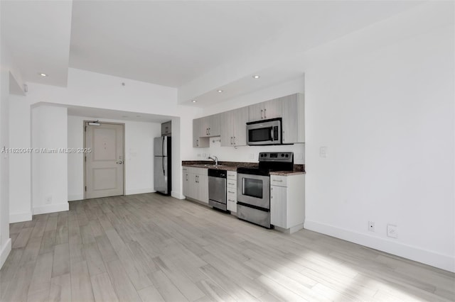 111 E Flagler St Unit 902, Miami, FL 33131 - kitchen with appliances with stainless steel finishes, light wood finished floors, recessed lighting, and dark countertops