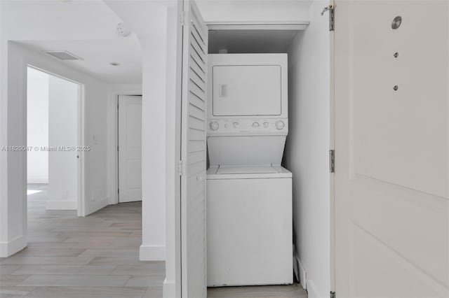 111 E Flagler St Unit 902, Miami, FL 33131 - washroom with stacked washing machine and dryer and light wood-type flooring