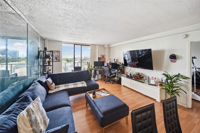 13499 Biscayne Blvd Unit 703, North Miami, FL 33181 - living area featuring light wood finished floors, a textured ceiling, a desk, and expansive windows