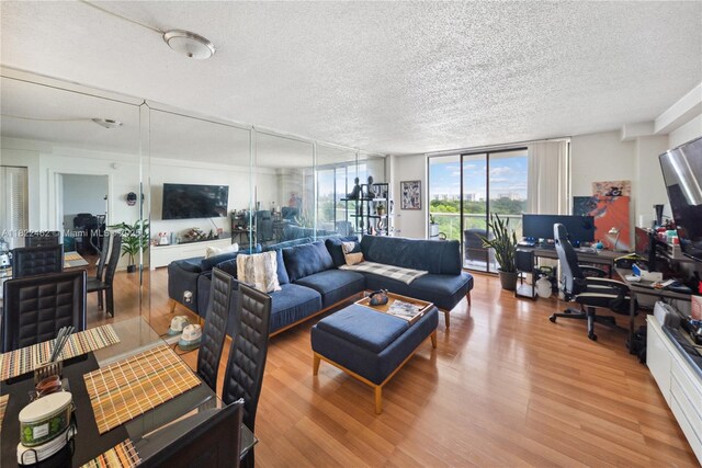 13499 Biscayne Blvd Unit 703, North Miami, FL 33181 - living area with a desk, a wall of windows, wood finished floors, and a textured ceiling