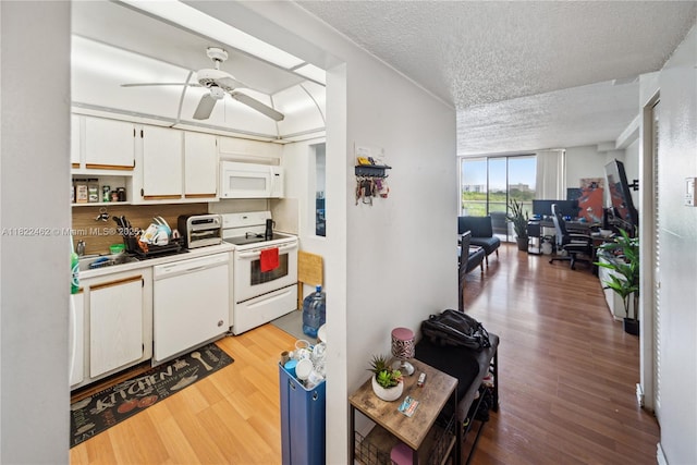 13499 Biscayne Blvd Unit 703, North Miami, FL 33181 - kitchen featuring white appliances, a textured ceiling, light wood-type flooring, white cabinets, and a ceiling fan