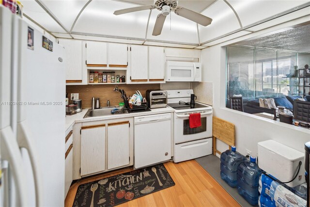 13499 Biscayne Blvd Unit 703, North Miami, FL 33181 - kitchen featuring white appliances, light countertops, light wood-style floors, white cabinets, and a ceiling fan