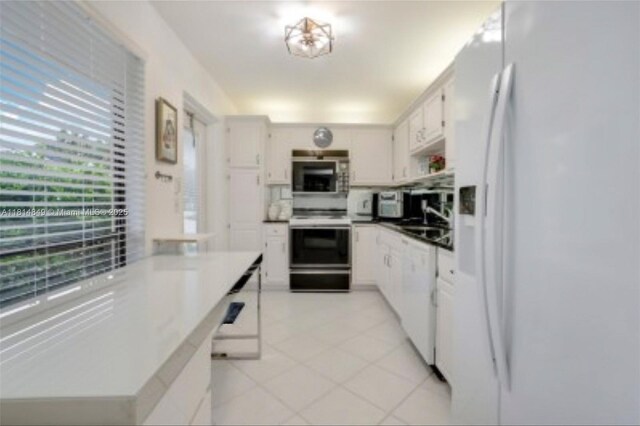 4650 Kittiwake Ct Unit 4650, Boynton Beach, FL 33436 - kitchen with white appliances, white cabinetry, and light tile patterned floors